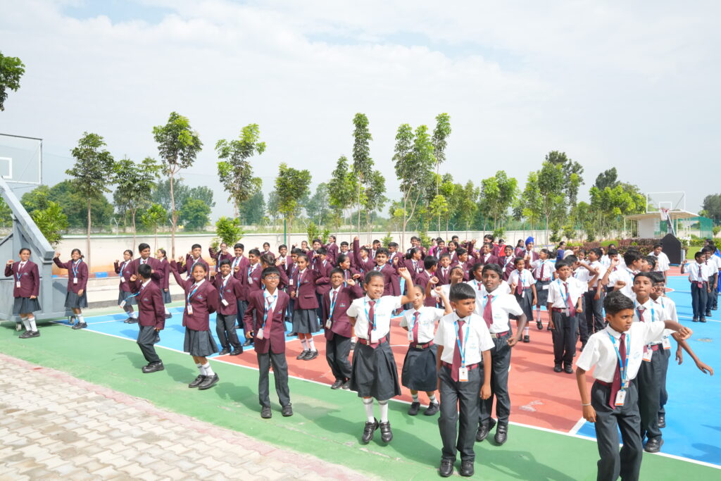 Aadya Academy Budigere students performing morning assembly exercises and activities on the outdoor sports court