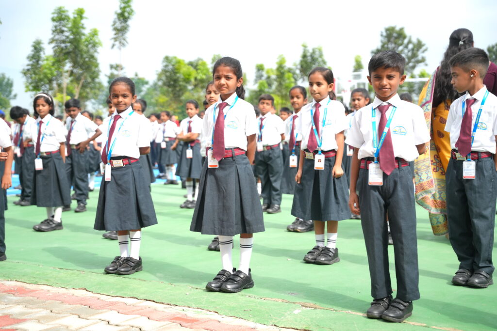 Aadya Academy Budigere primary school students standing in neat rows during outdoor morning assembly